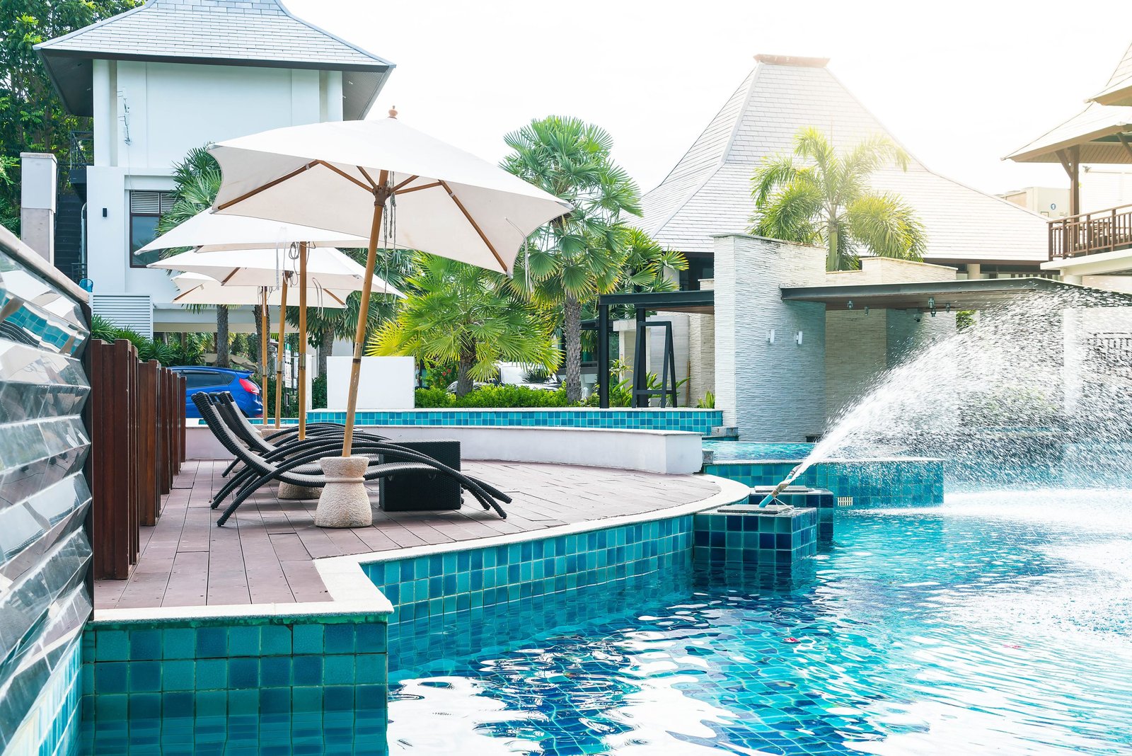 Beautiful luxury hotel swimming pool resort with umbrella and chair - with sunflare effect